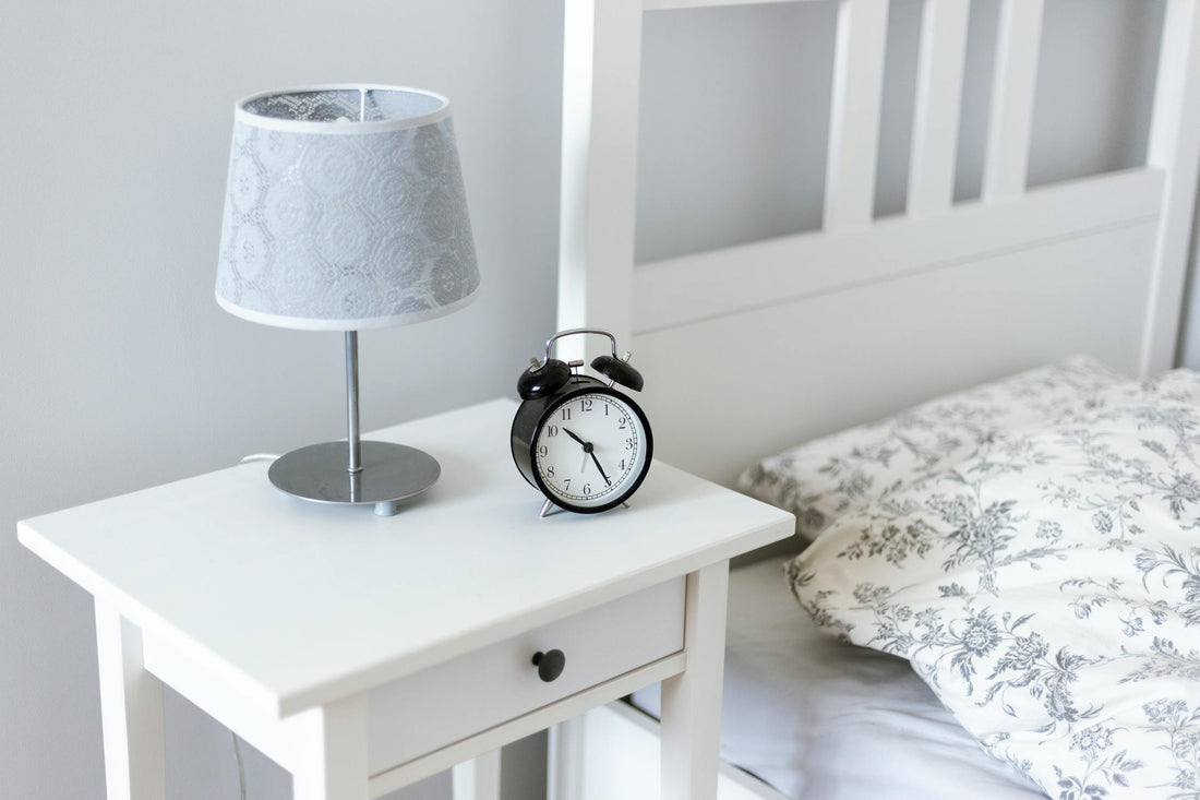 Bedside table with alarm clock and lamp in a well-organized bedroom - Mattress Miracle Brantford
