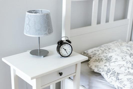 Bedside table with alarm clock and lamp in a well-organized bedroom - Mattress Miracle Brantford