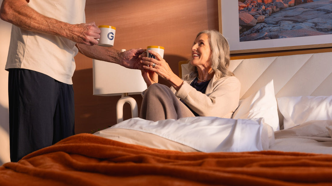 Couple sharing morning coffee in bed on a GoodMorning.com mattress - Mattress Miracle Brantford