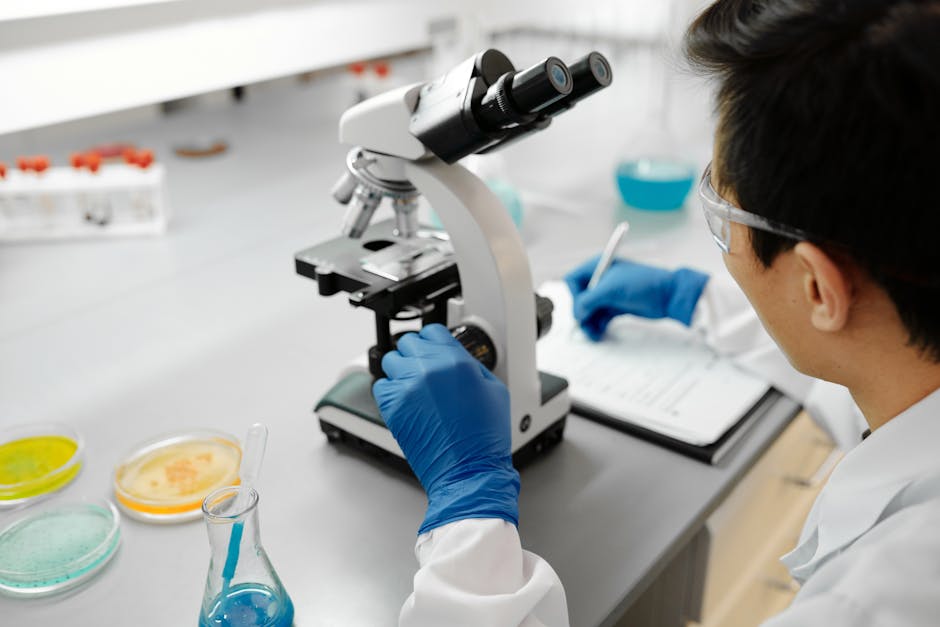 Lab technician at microscope representing diagnostic healthcare work