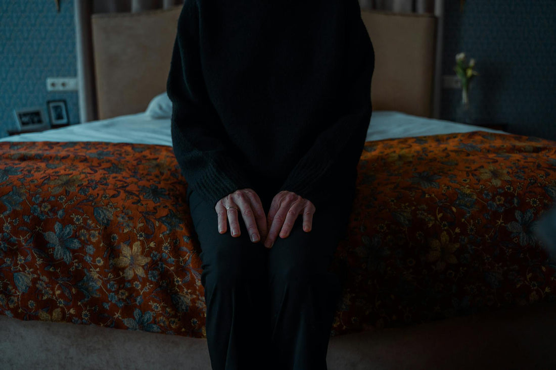 Person sitting on the edge of a bed demonstrating mattress edge support stability