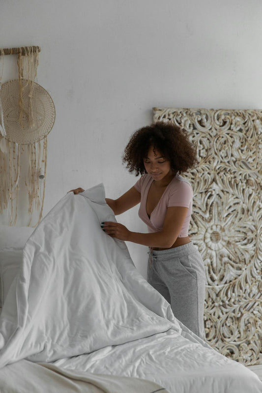 Woman fixing and adjusting mattress bedding