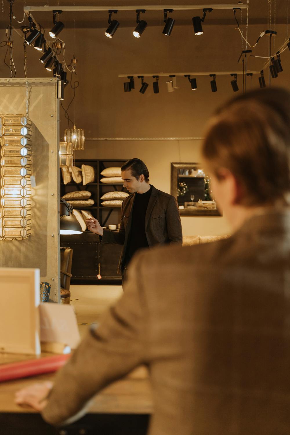 Man browsing furniture and pillows in a mattress store showroom