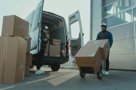 Delivery workers loading boxes into pickup van for removal