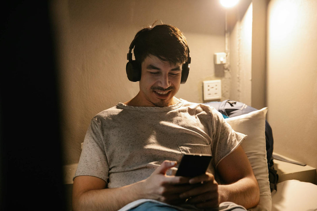 Relaxing with headphones in bed listening to sleep podcast - Mattress Miracle