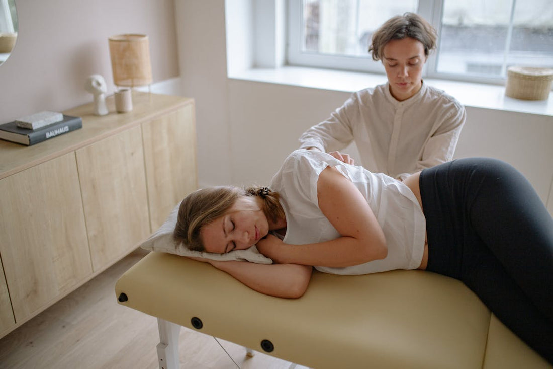 Massage therapist providing therapeutic treatment showing occupational posture demands
