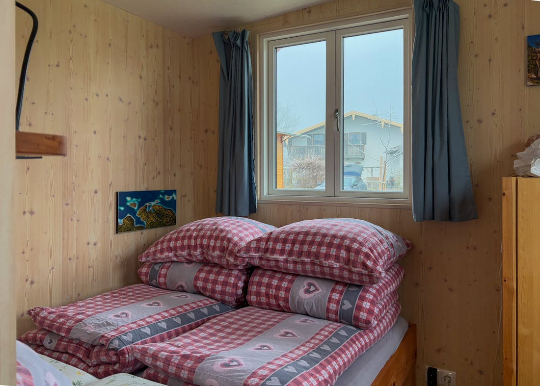 Cozy tiny house cabin bedroom with plaid bedding and window view