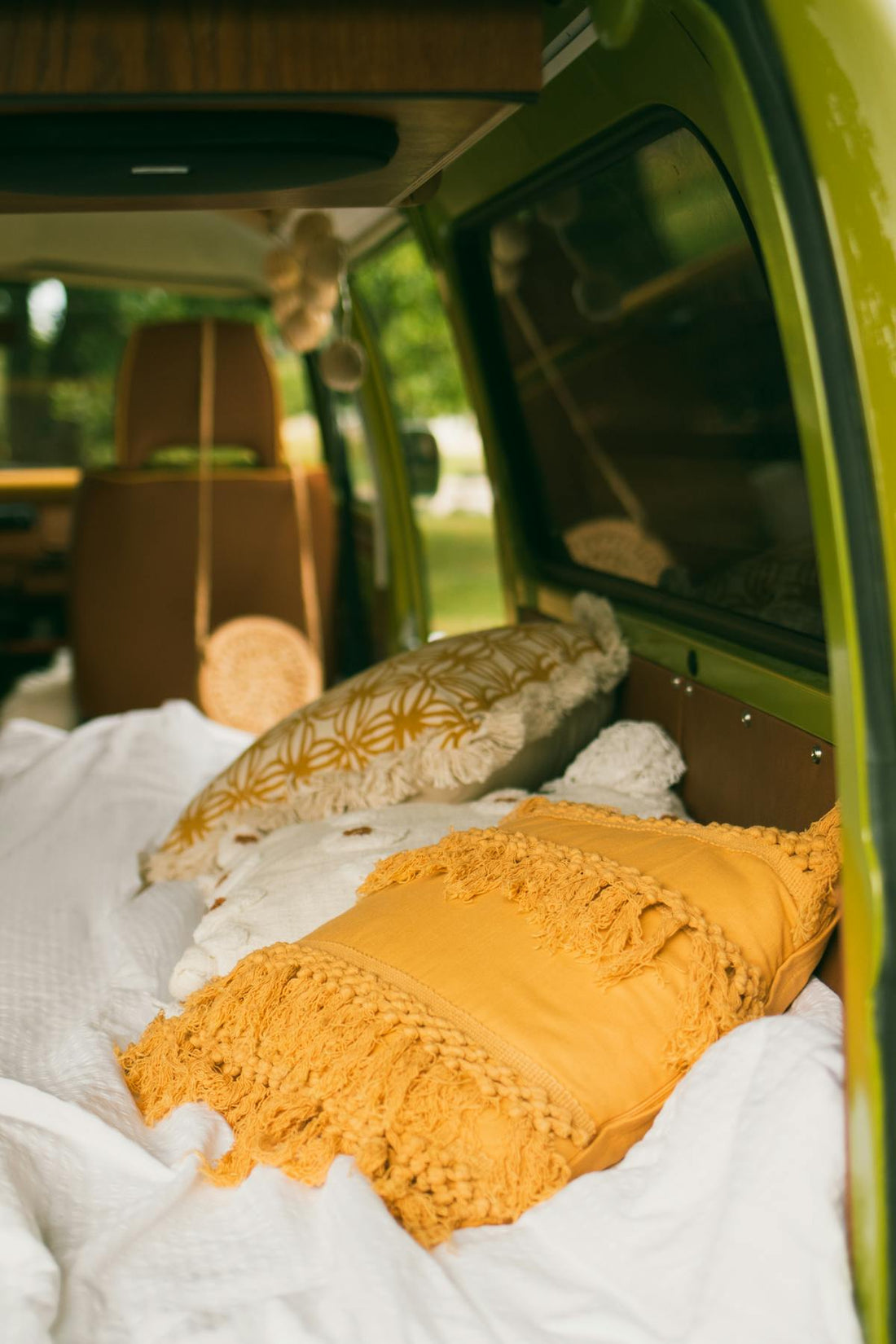 Cozy camper van interior with colorful pillows and bedding for van life sleeping