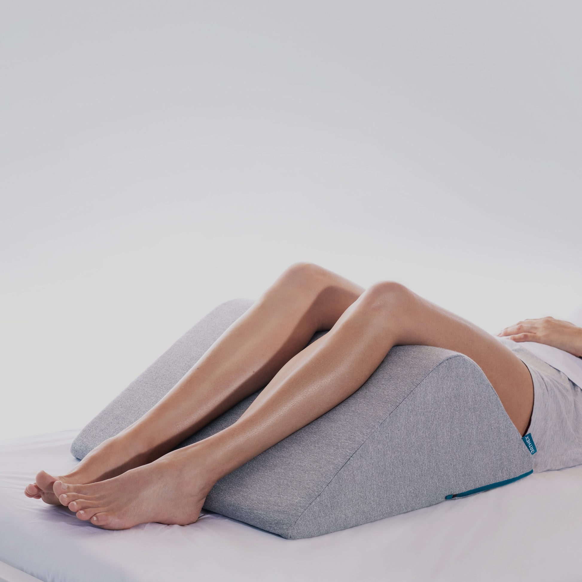 Orthex Symbia 10 inch ergonomic leg bolster elevating the legs in use - Mattress Miracle Brantford