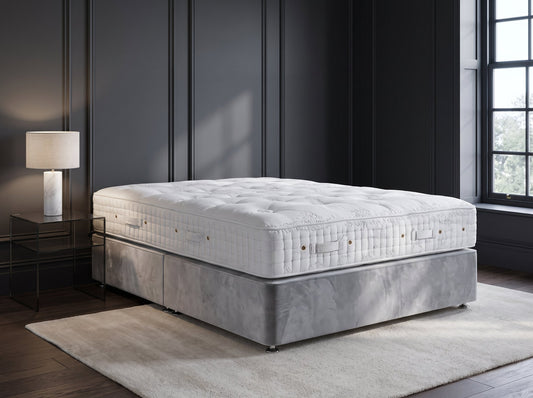 Hypnos Eminence mattress styled on a silver velvet divan against charcoal panelling