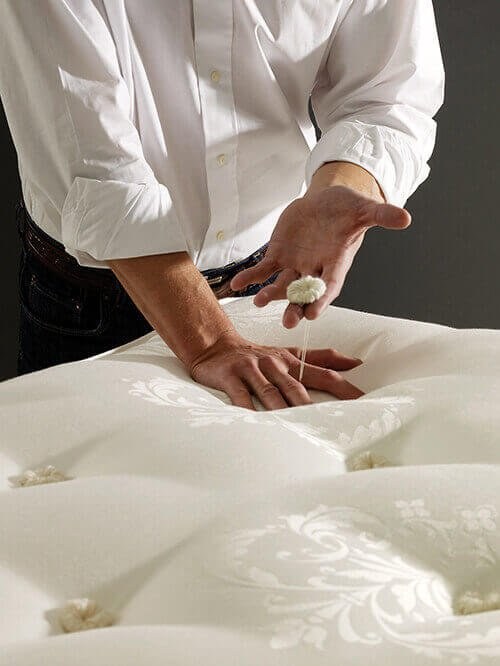 Hand-tufting with wool rosettes on a Hypnos mattress - Mattress Miracle Brantford