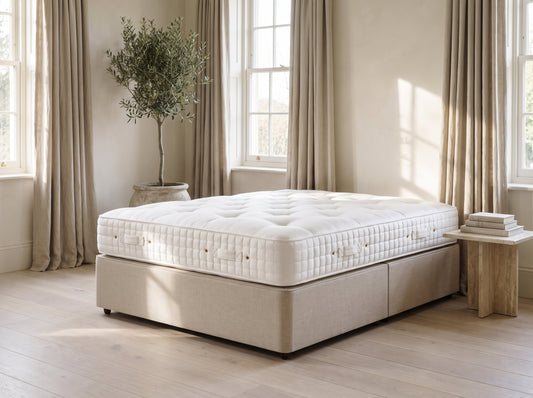 Hypnos St. James mattress styled on an oatmeal linen divan in a natural luxury bedroom